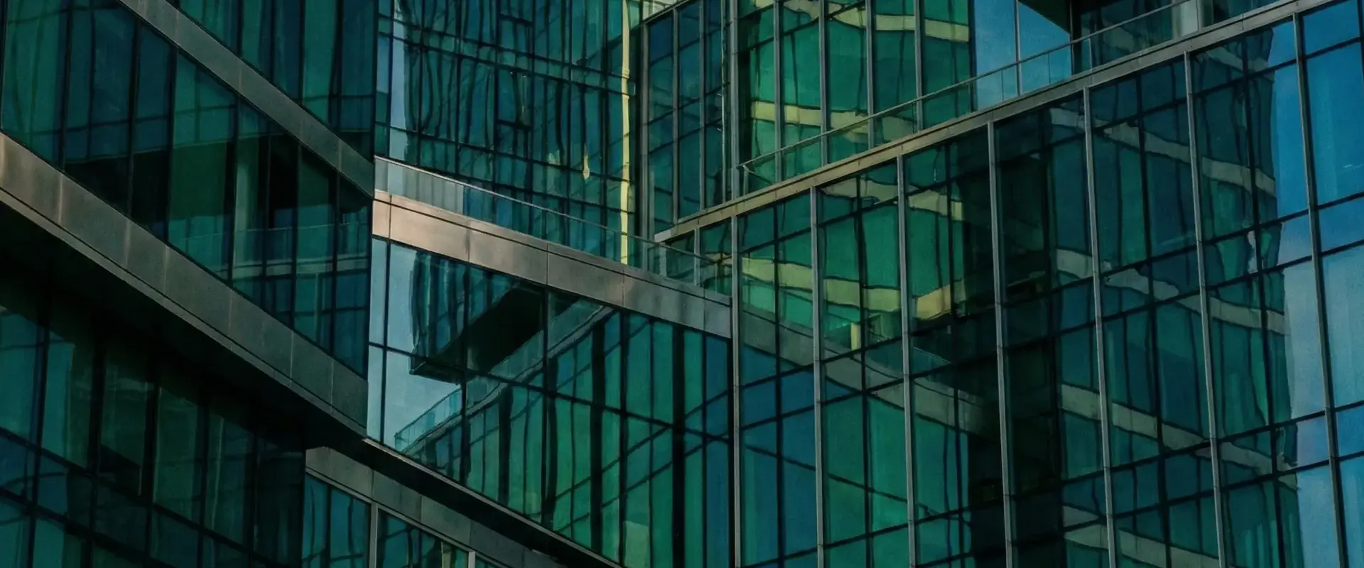 Modern glass skyscraper facades with teal reflections