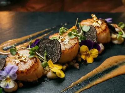 Fine dining dish with truffle and edible flowers on dark slate